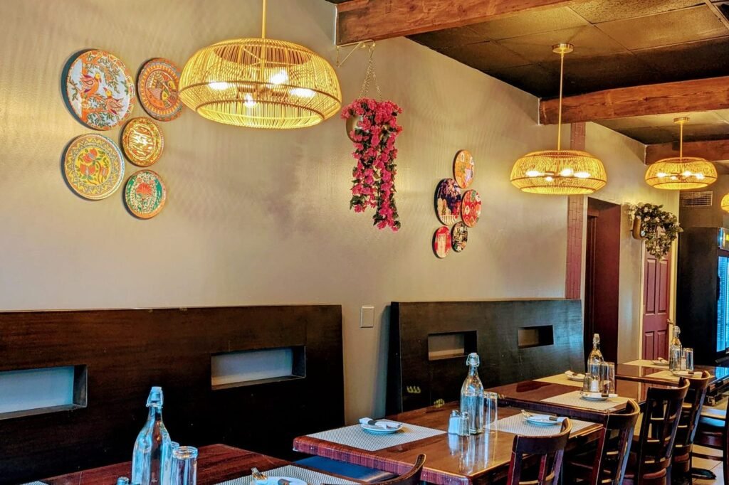 Hand-painted Indian plates on the wall beside a woven pendant light